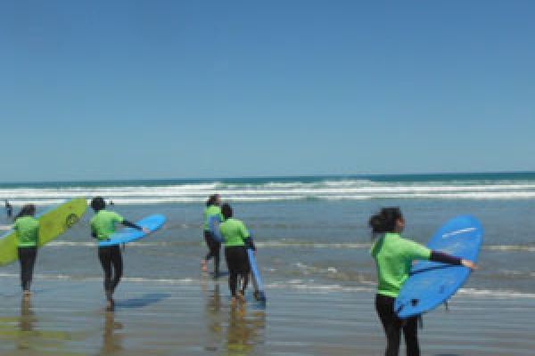 kids going to the beach with their surf boards for surf lessons moana
