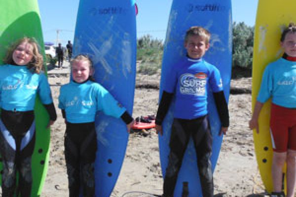 kids surfing with surf board for surf lessons Middleton