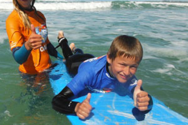 kid surfing with instructor