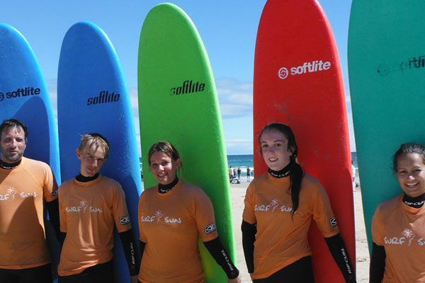 surfing students posing with their surfboards