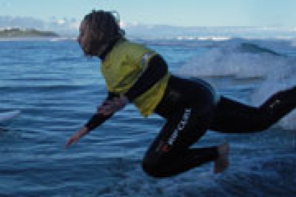 Man jumping in the water for surf lessons Middleton