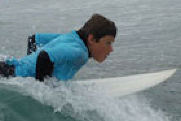 a man learning to lie on a surfboard